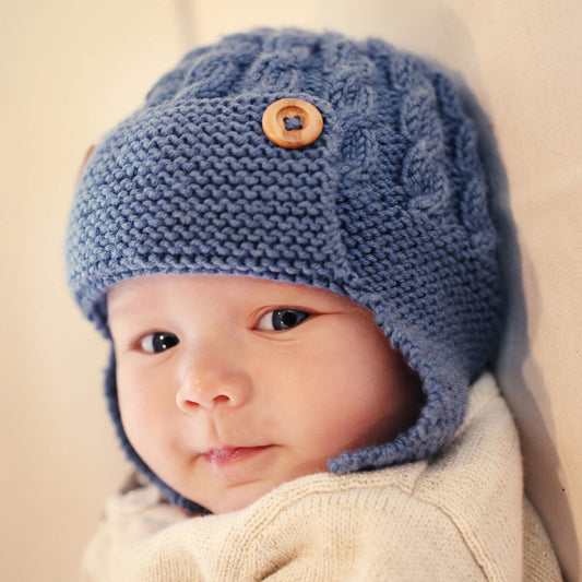 child modelling a baby aviator hat knitting pattern