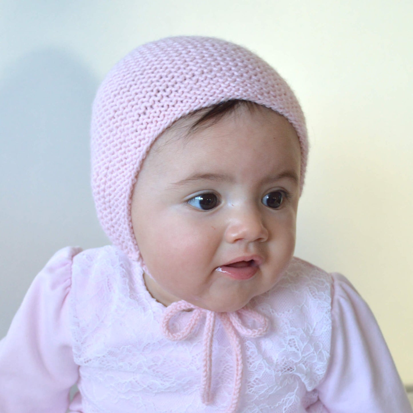 Baby modelling a sample for a baby bonnet knitting pattern