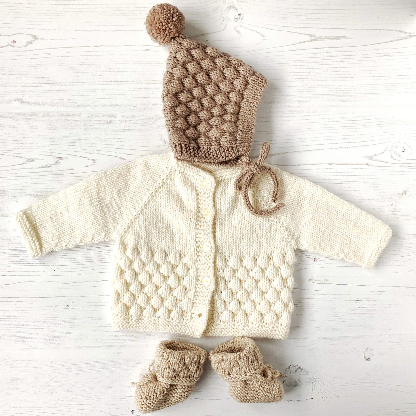 baby bubble stitch knit patterns shown in cream and fawn