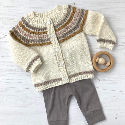 a baby cardigan knit pattern shwn as a baby outfit with grey leggings