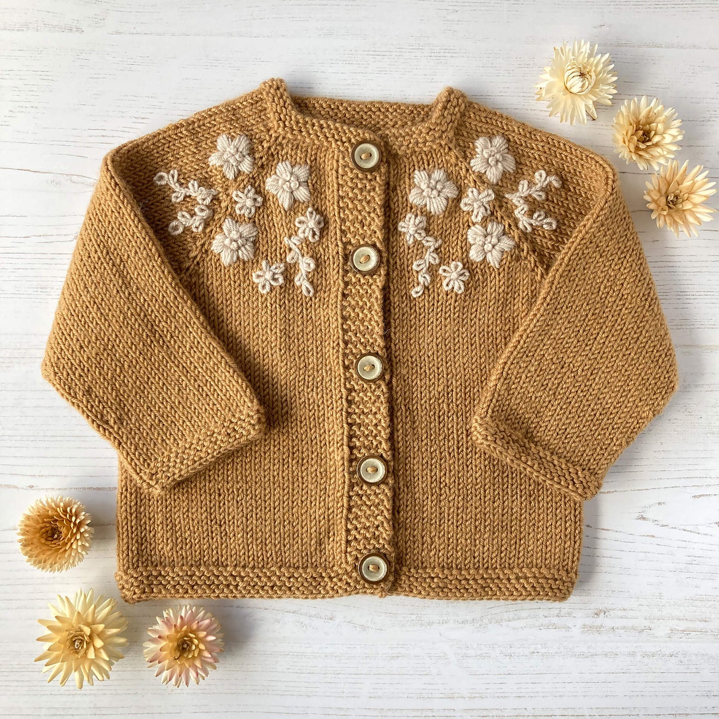 a baby cardigan knitting pattern with flower embroidery