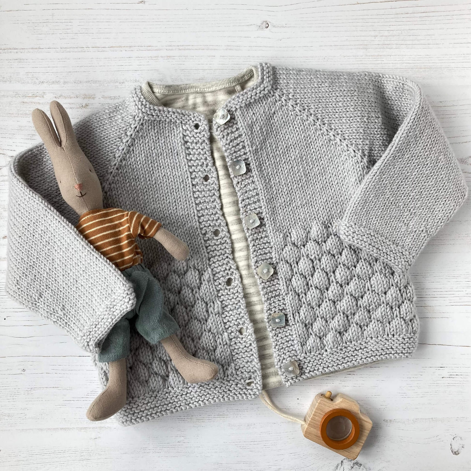 a knitted sample for a top down knitting pattern for a  baby cardigan 