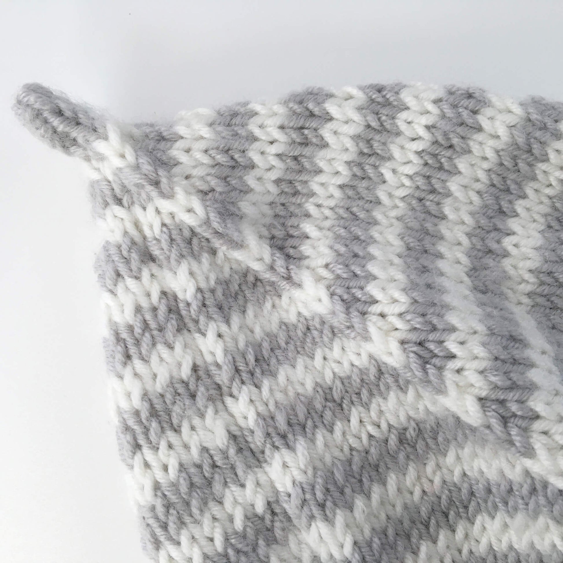 a close up view of the stalk at the top of this baby pixie hat knitting pattern