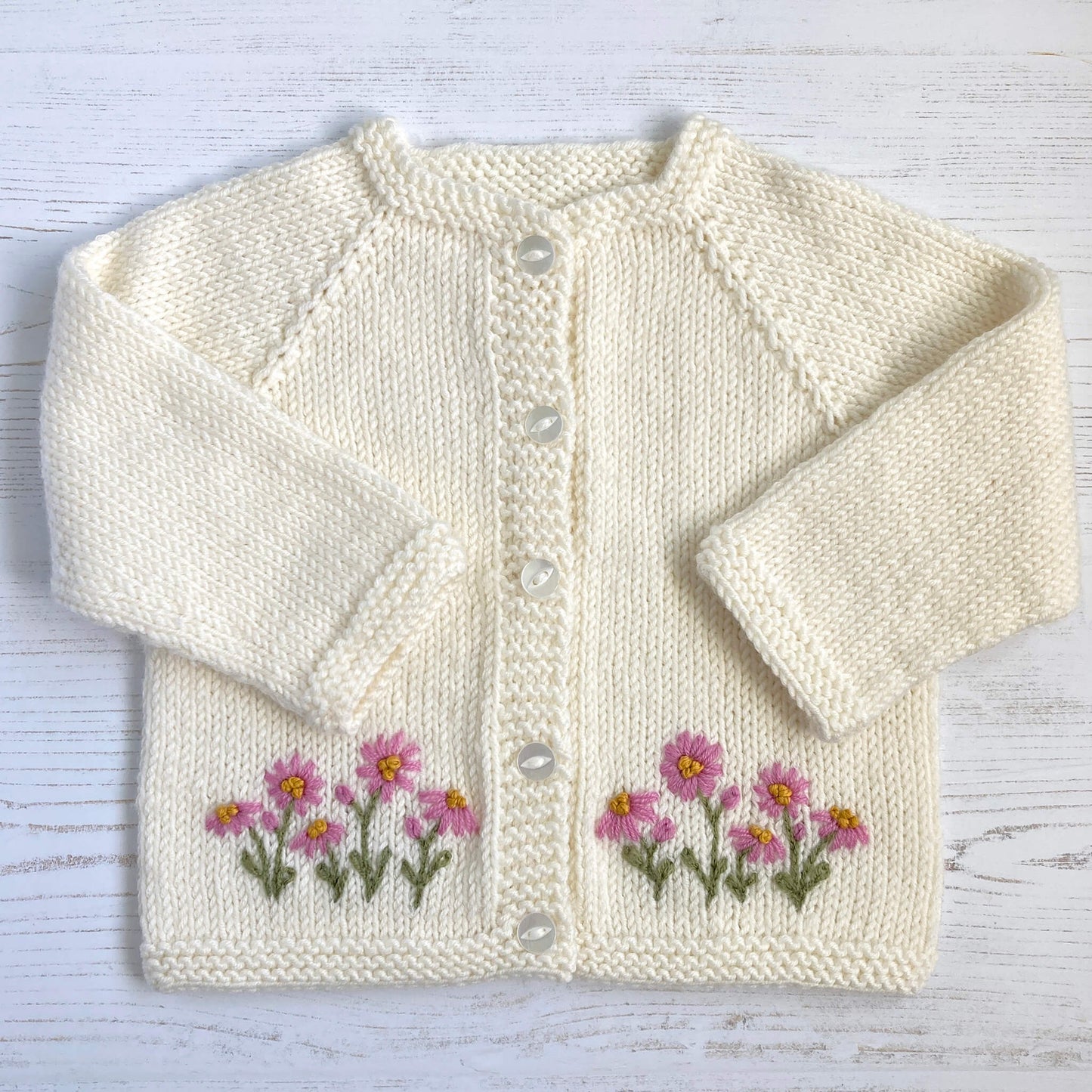 a simple baby knitting pattern with embroidered daisies