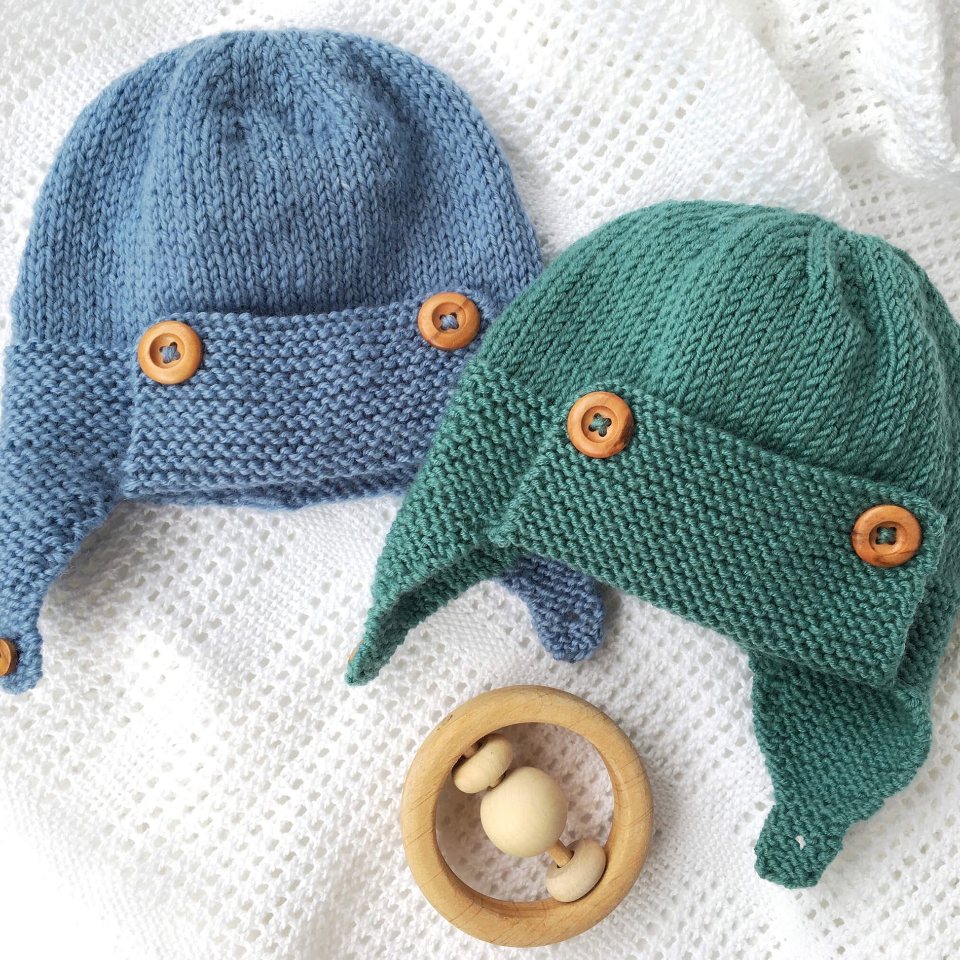 baby pilot hat knit pattern, two samples shown in blue and sea green