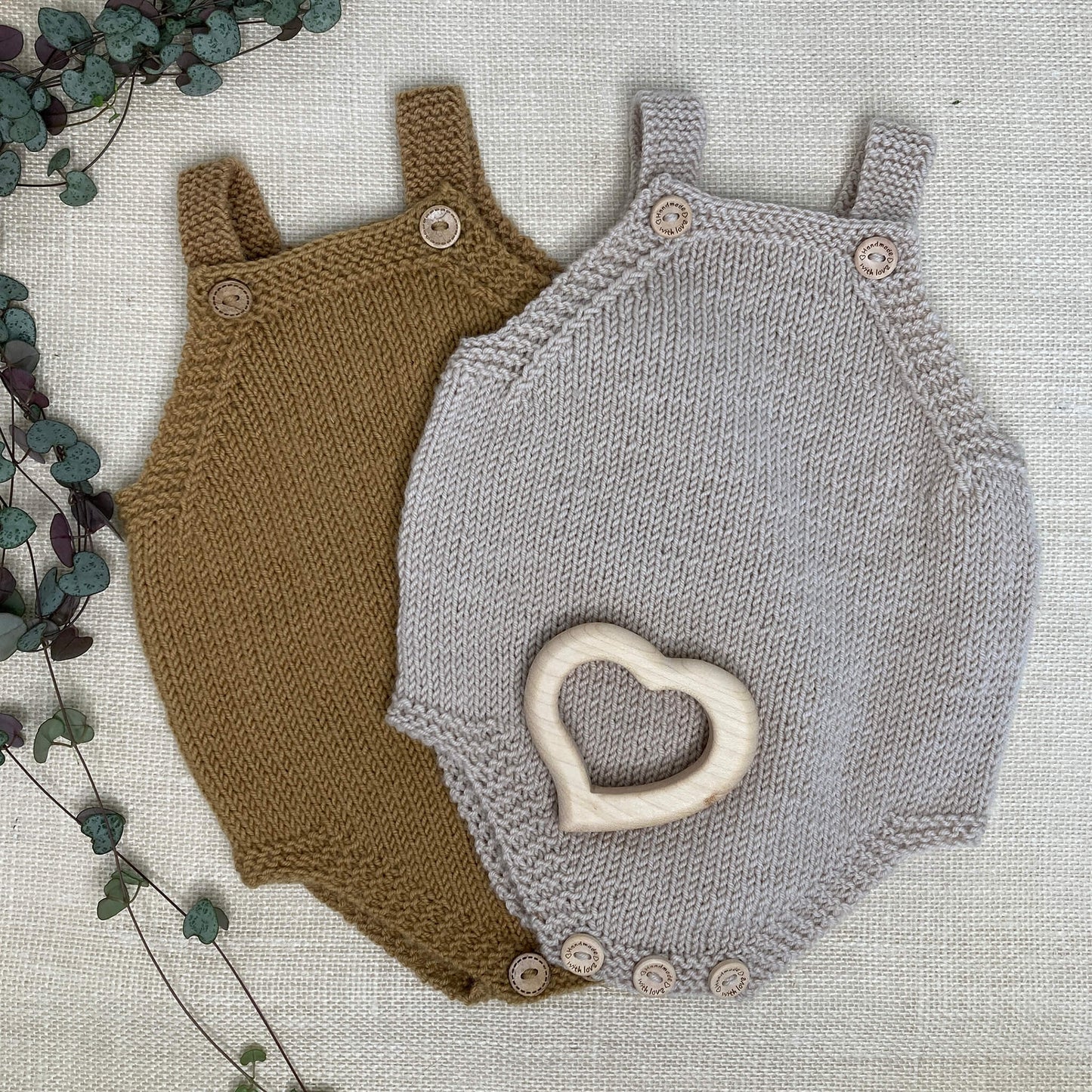 two rompers in mustard and light grey. they are samples for a simple baby romper knitting pattern