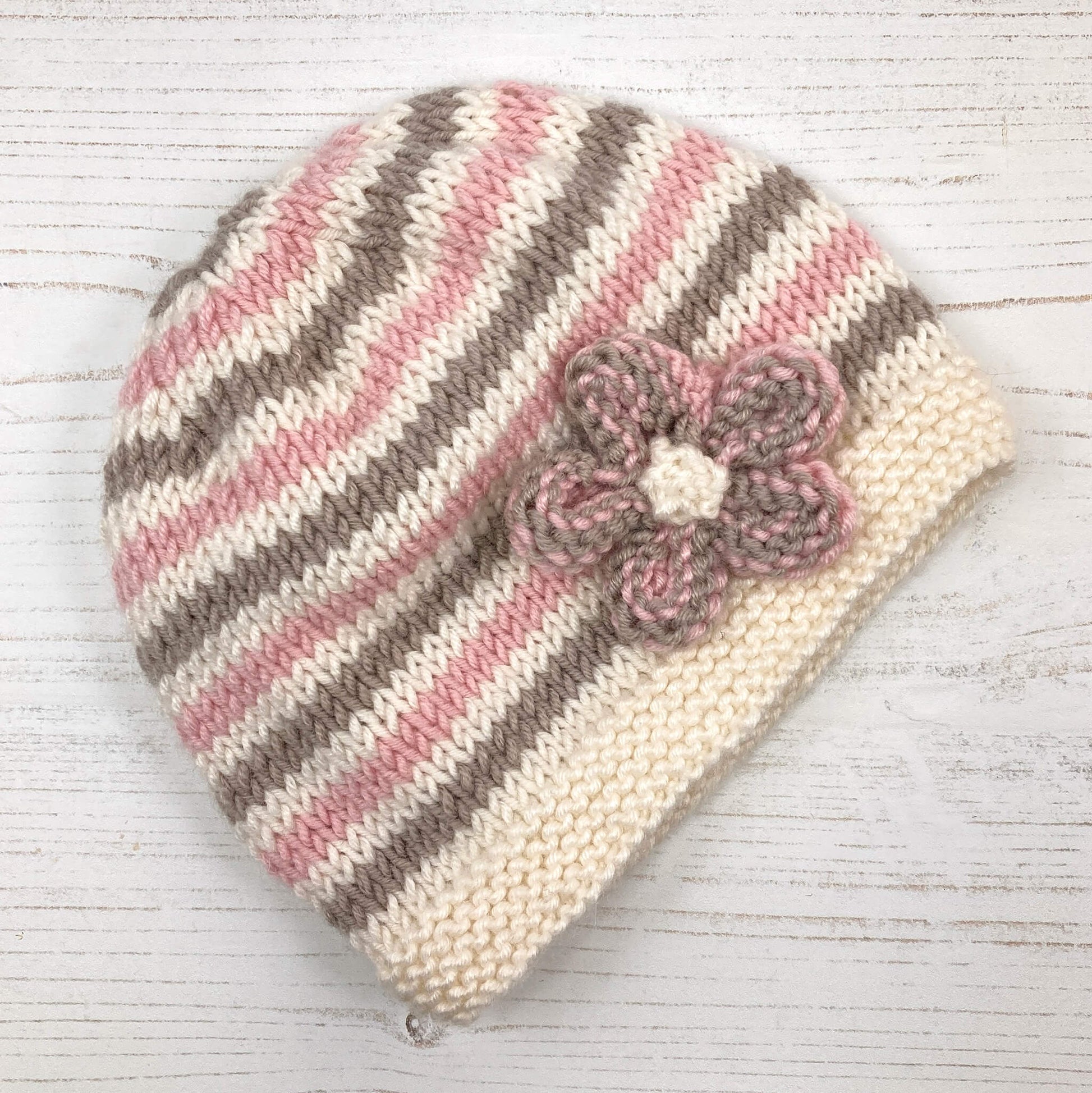 a beginner level baby hat knitting pattern with a flower