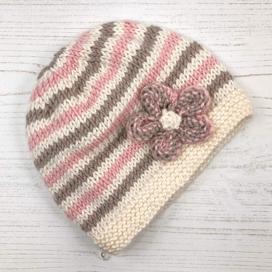 a beginner level baby hat knitting pattern with a flower