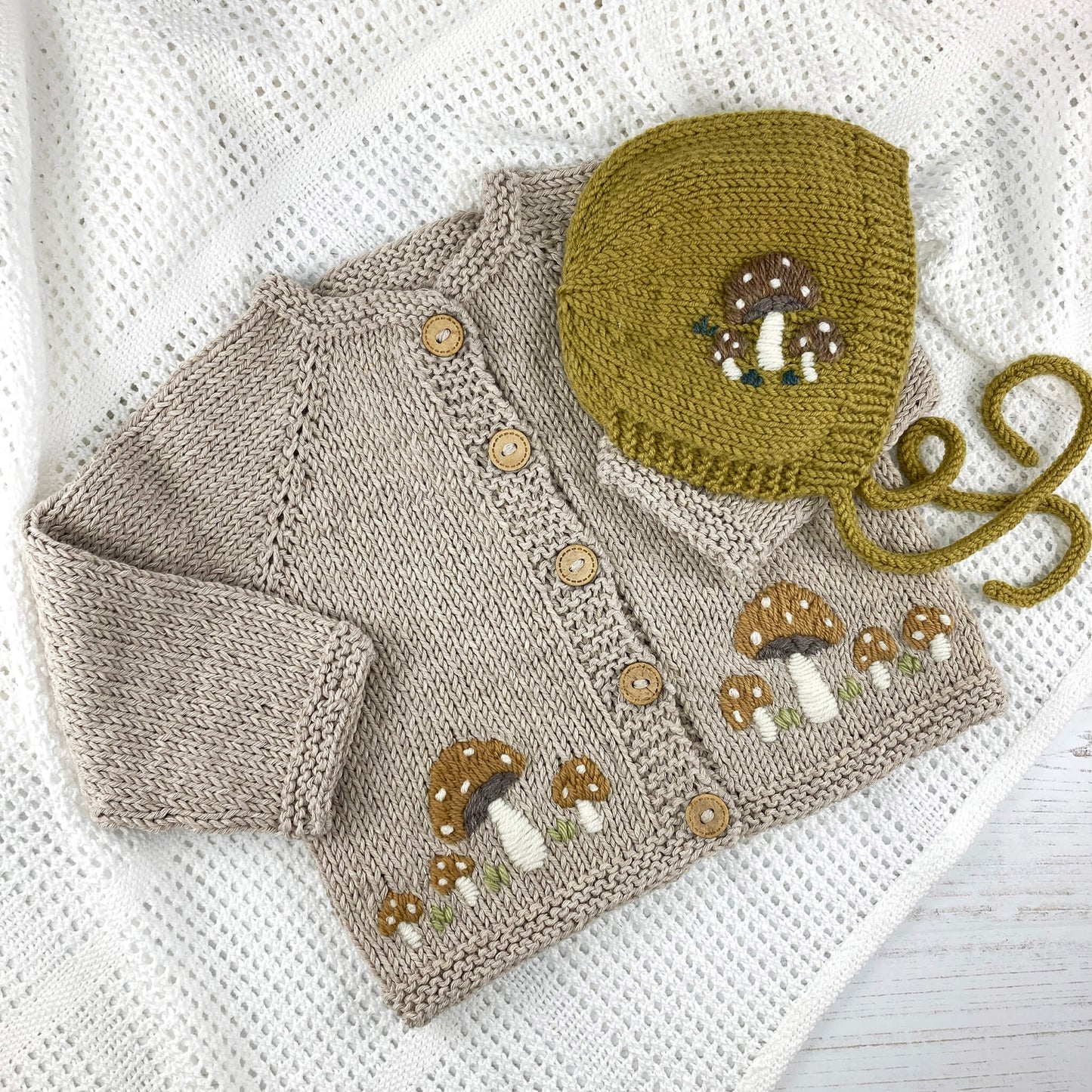 a baby bonnet and cardigan knitting pattern with included mushroom embroidery