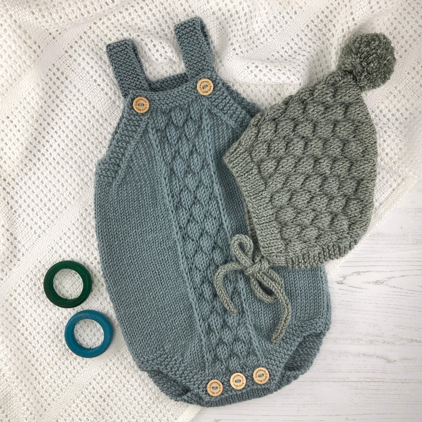 baby knitting patterns with bubble stitch. a romper and pixie hat in blue and sage yarn