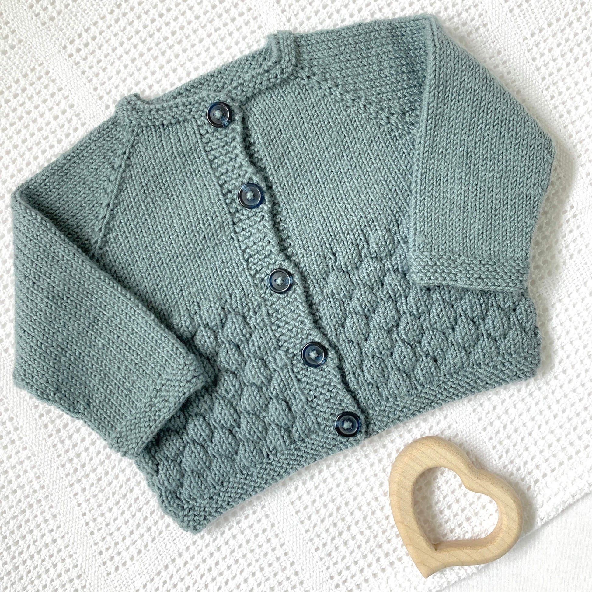 a blue grey baby cardigan sample for a bubble stitch knit pattern