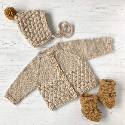 bubble stitch knit patterns for baby featuring a baby cardigan, a pixie hat and booties in fawn and mustard colours