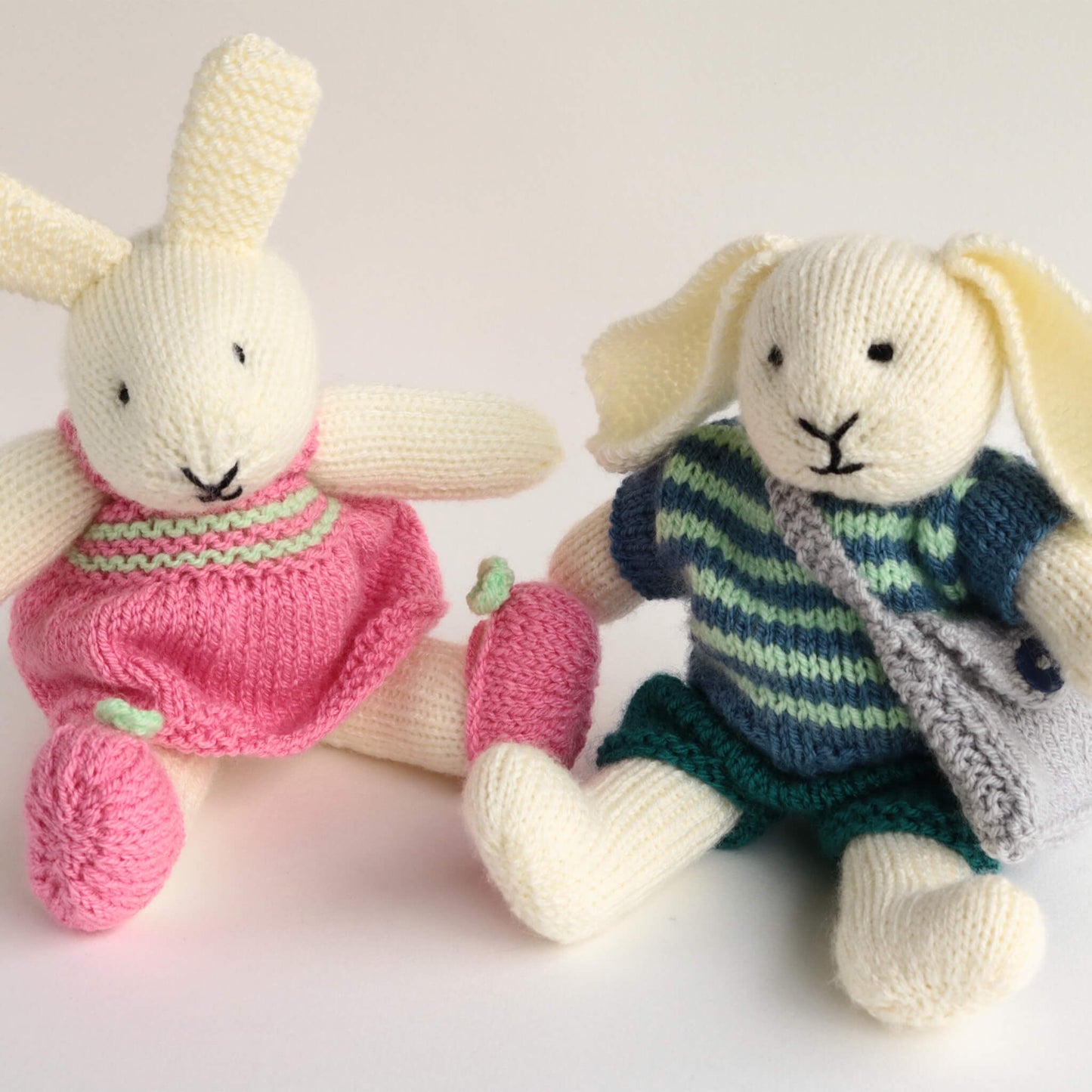 a bunny knitting pattern. bunnies are dressed in pink and blue clothing