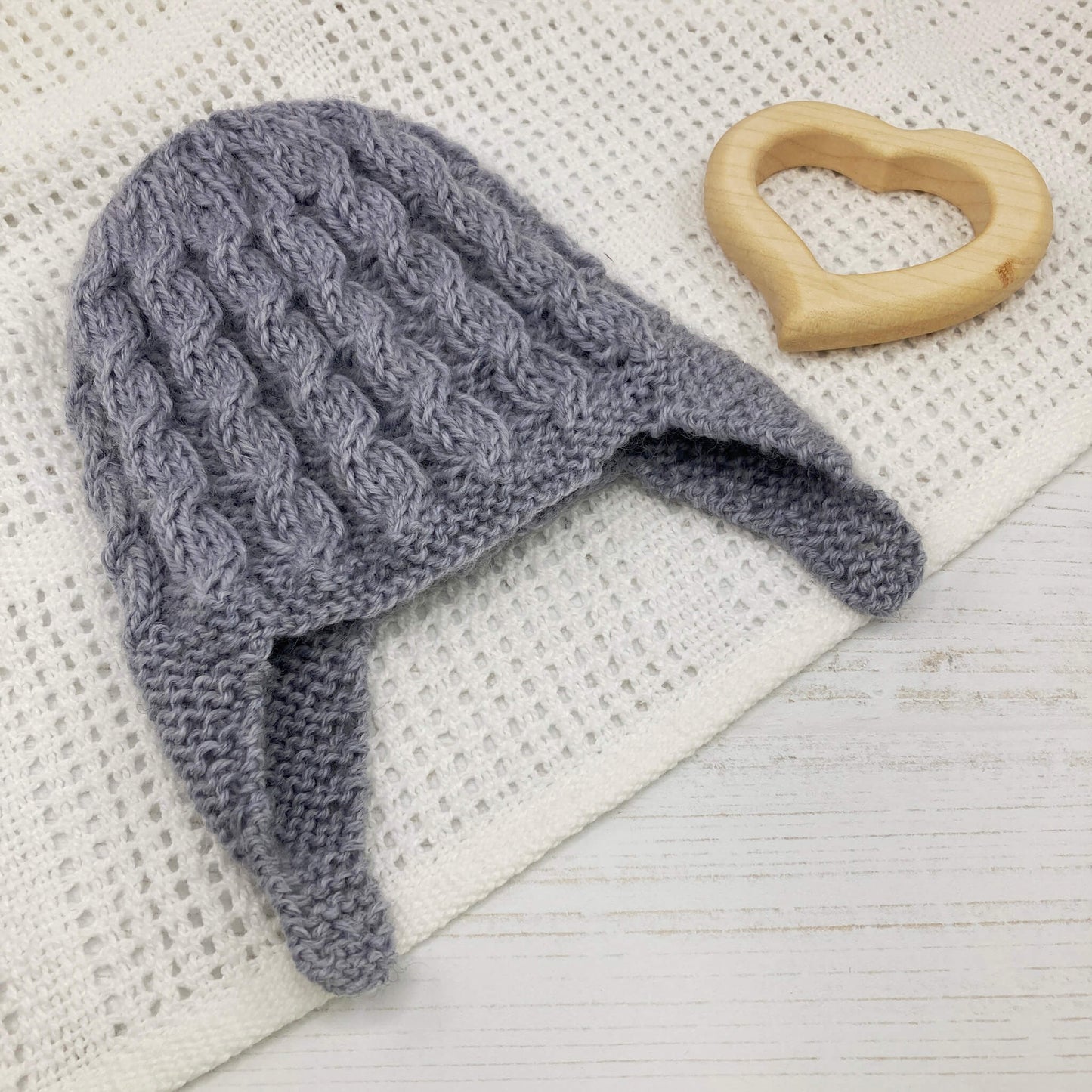 a cable knitting pattern for a baby hat