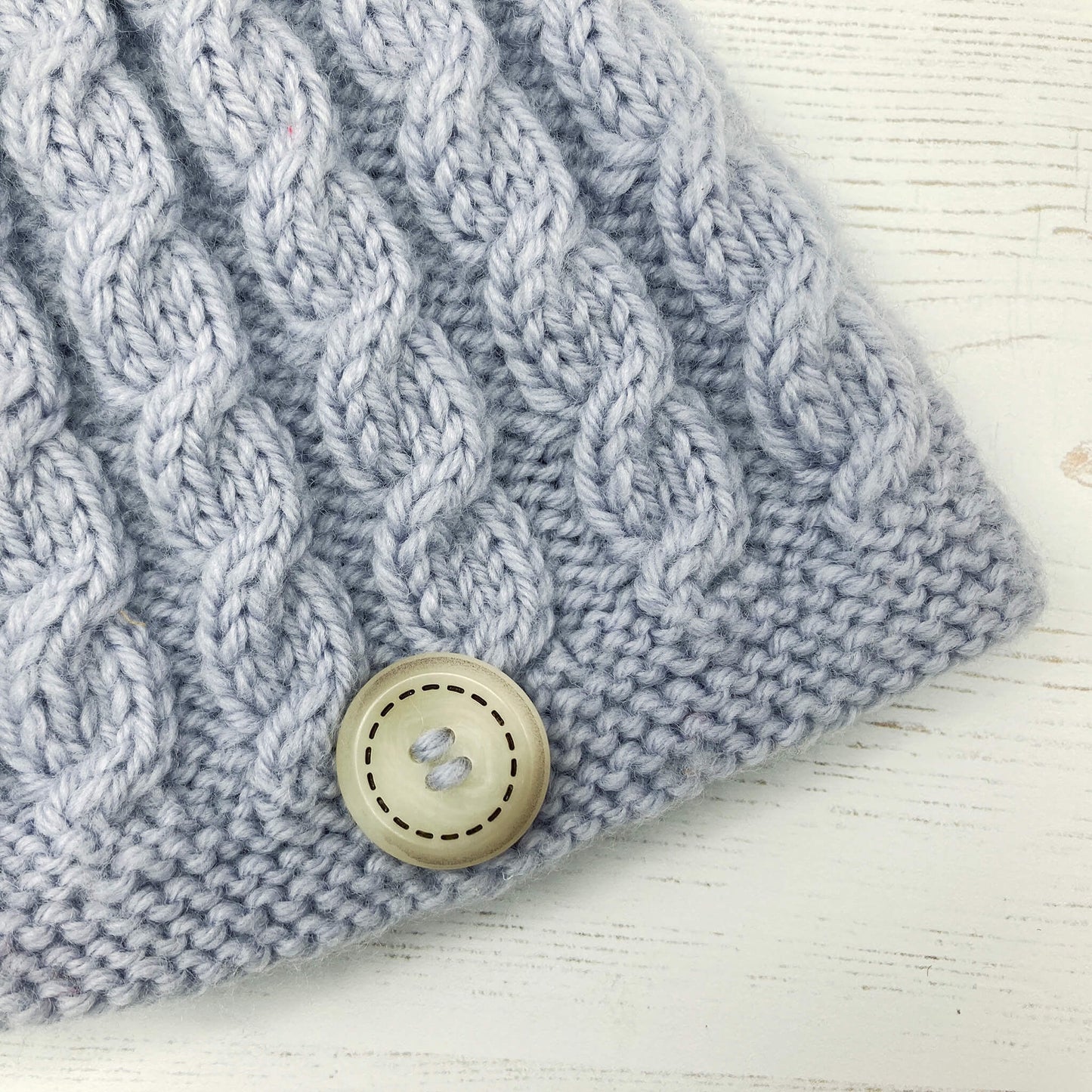 a close up view of the cables on a baby hat knitting pattern