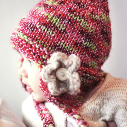 an earflap hat pattern modelled by a baby