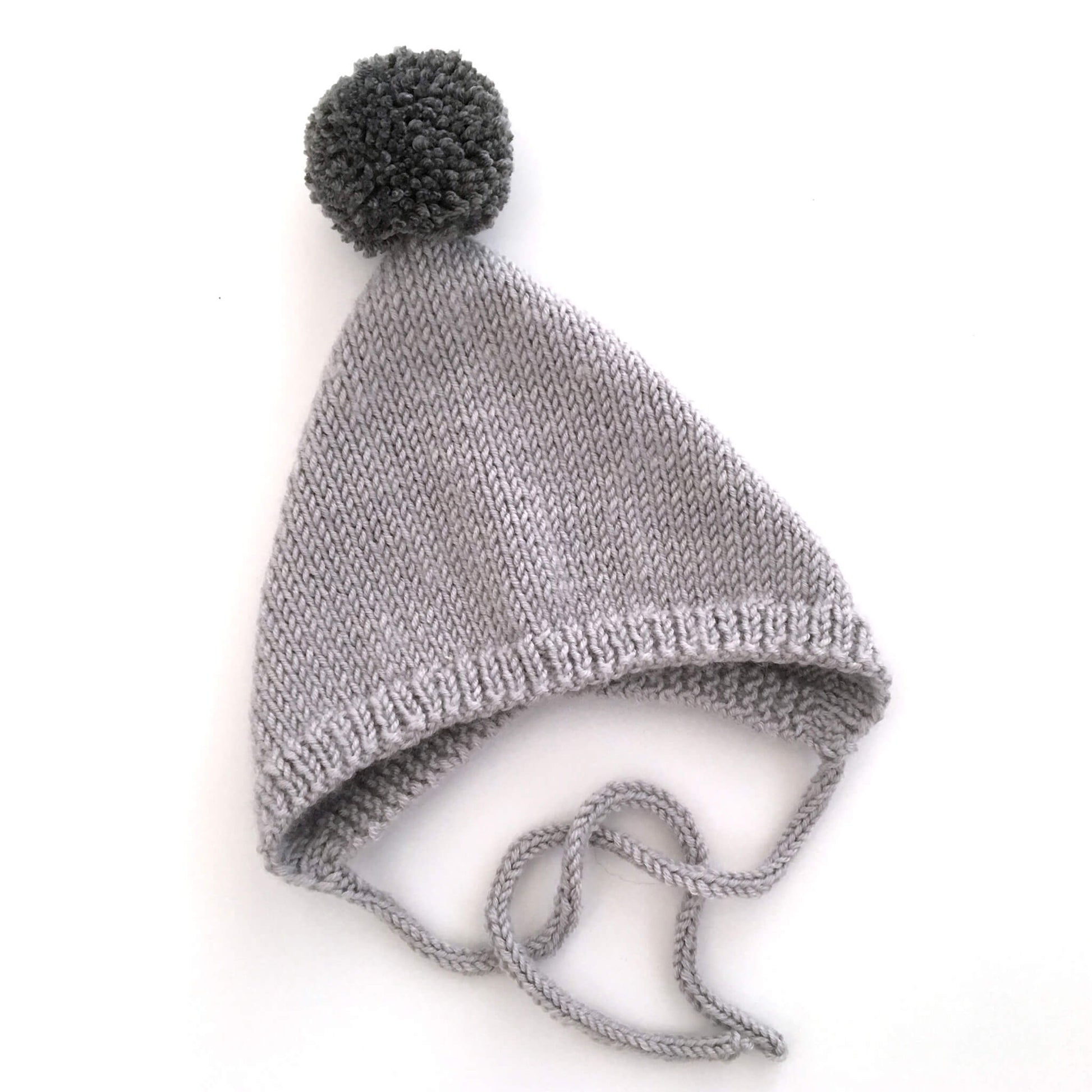 easy pixie hat knitting pattern, shown in grey with dark grey pompom