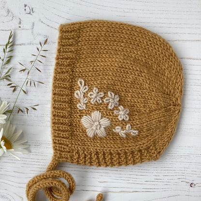 photo of an embroidered baby bonnet knitting pattern