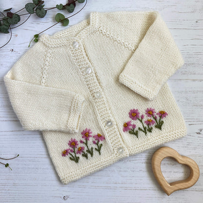 a knitting pattern for a baby cardigan with daisy embroidery 