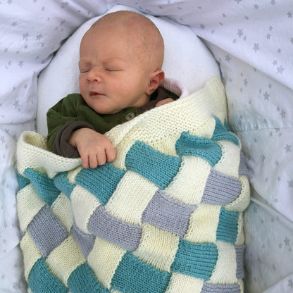 sleeping baby modelling an entrelac baby blanket knitting pattern