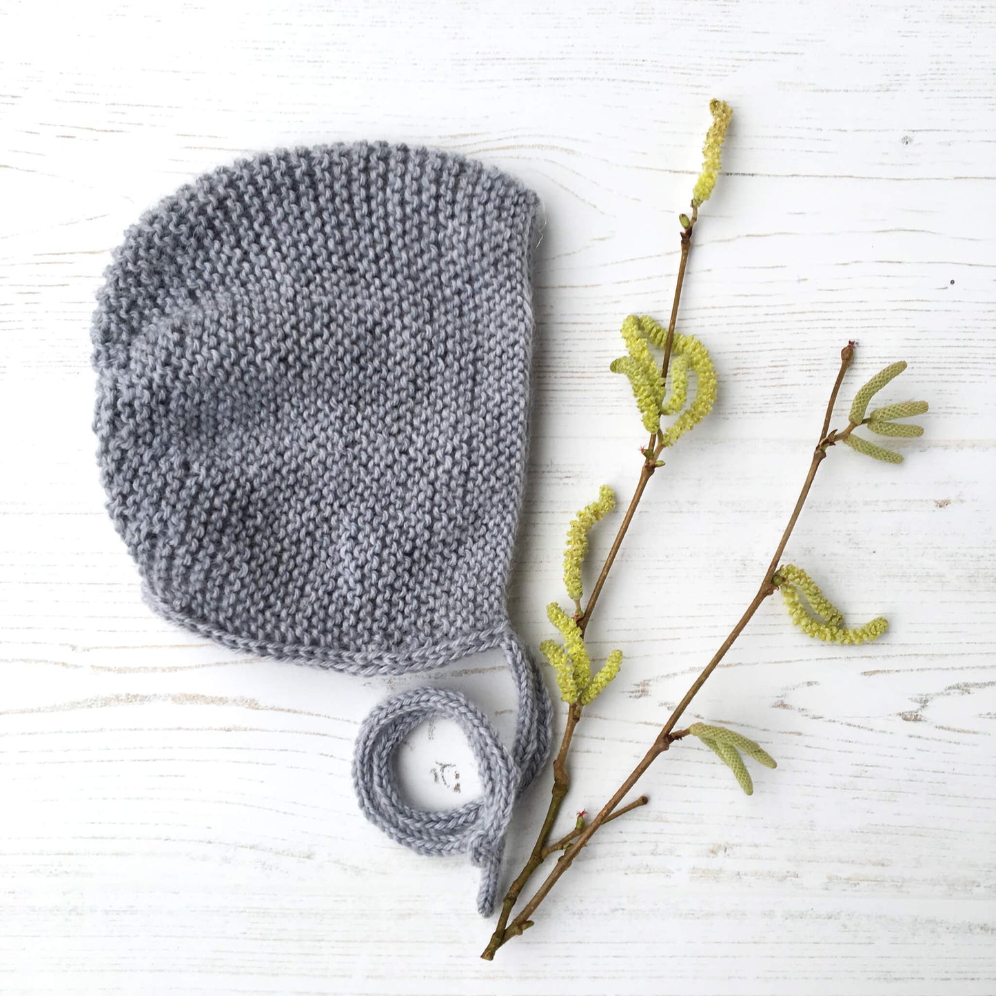 A garter stitch bonnet knitting pattern. Samople is shown in grey yarn