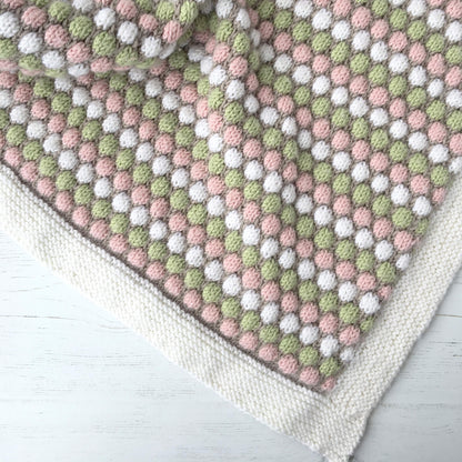 flatlay photo of a knit baby blanket pattern