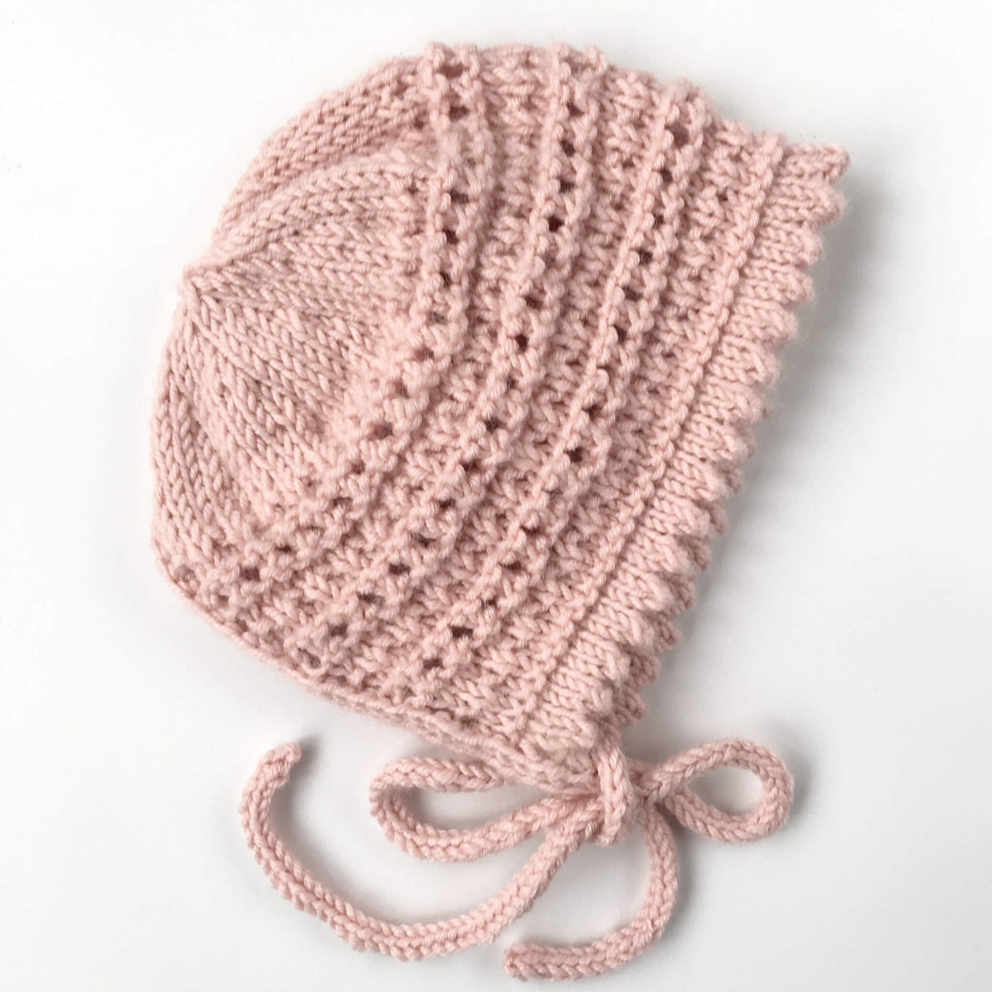 a knit pattern for a bay bonnet shown in pale pink