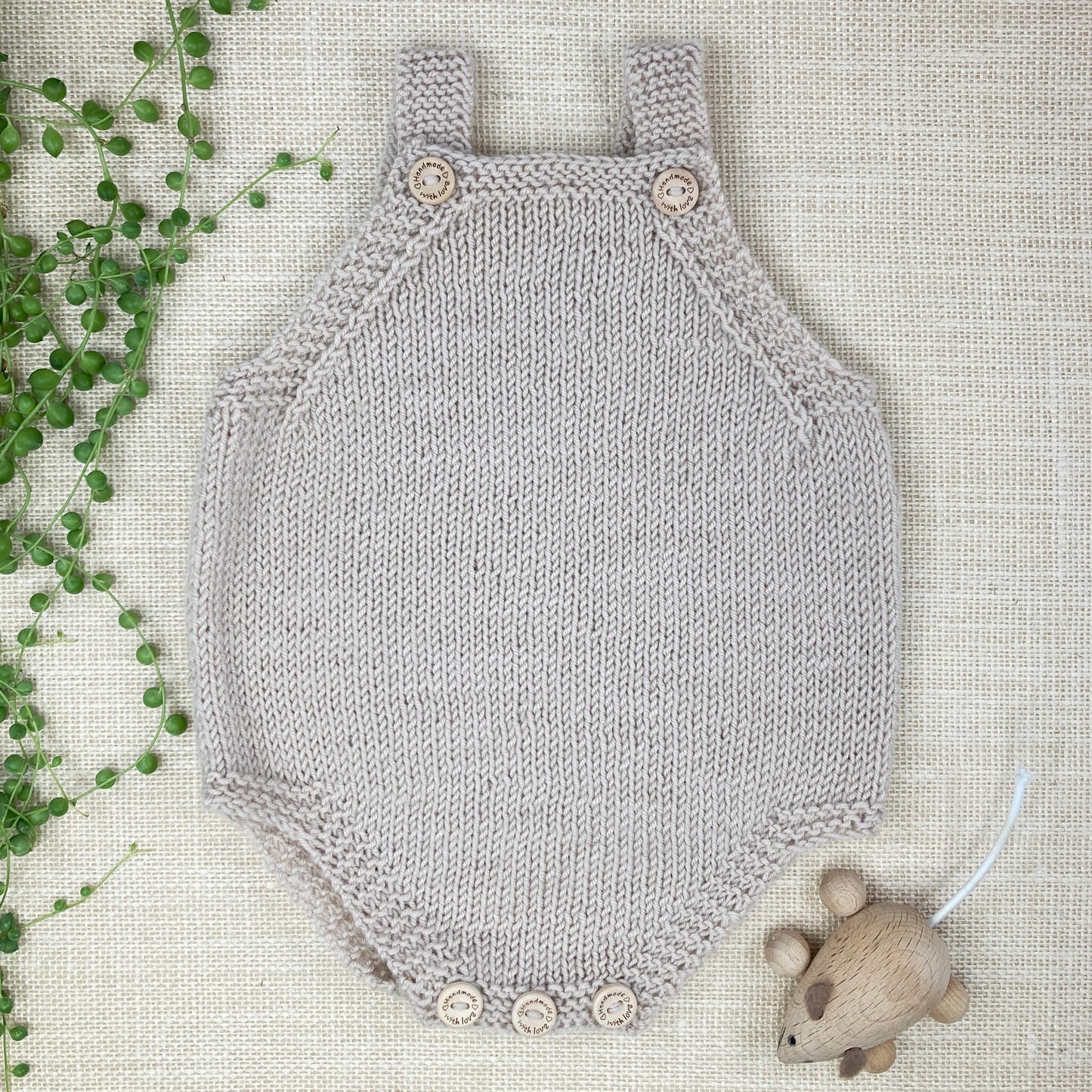 an easy knitting pattern for a baby romper,  sample is shown in light grey