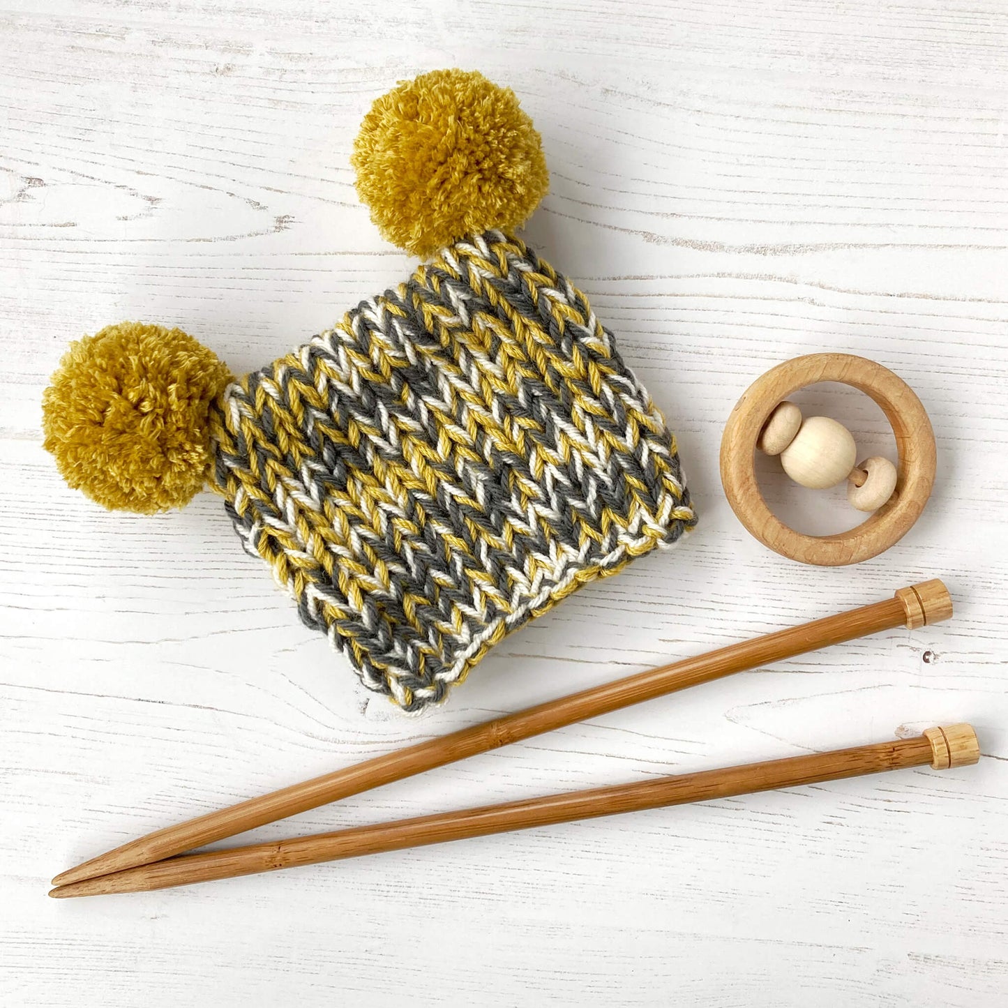 an easy knitting pattern for a baby hat shown in mustard and grey