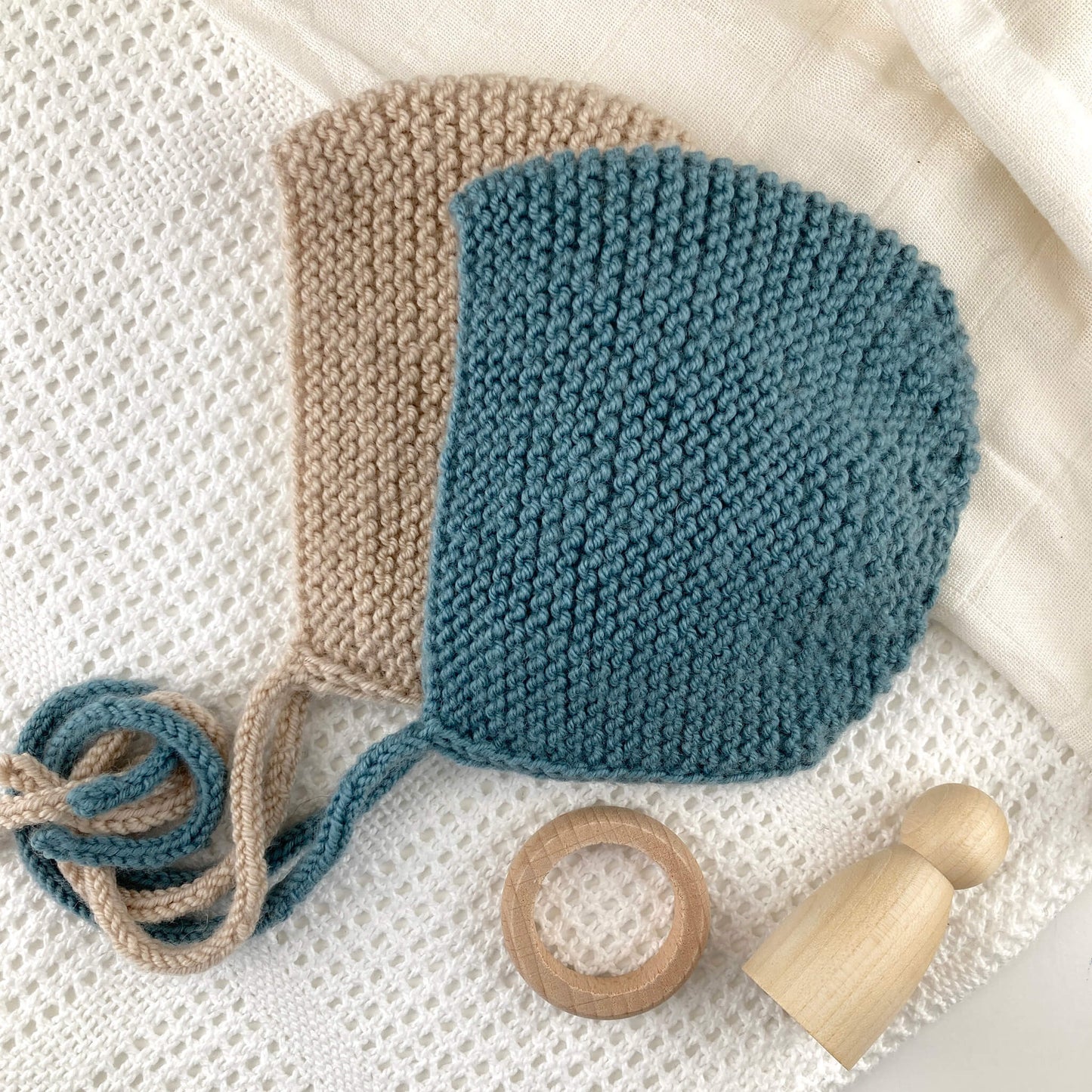 A flatlay image of a knitting pattern for a garter stitch baby bonnet