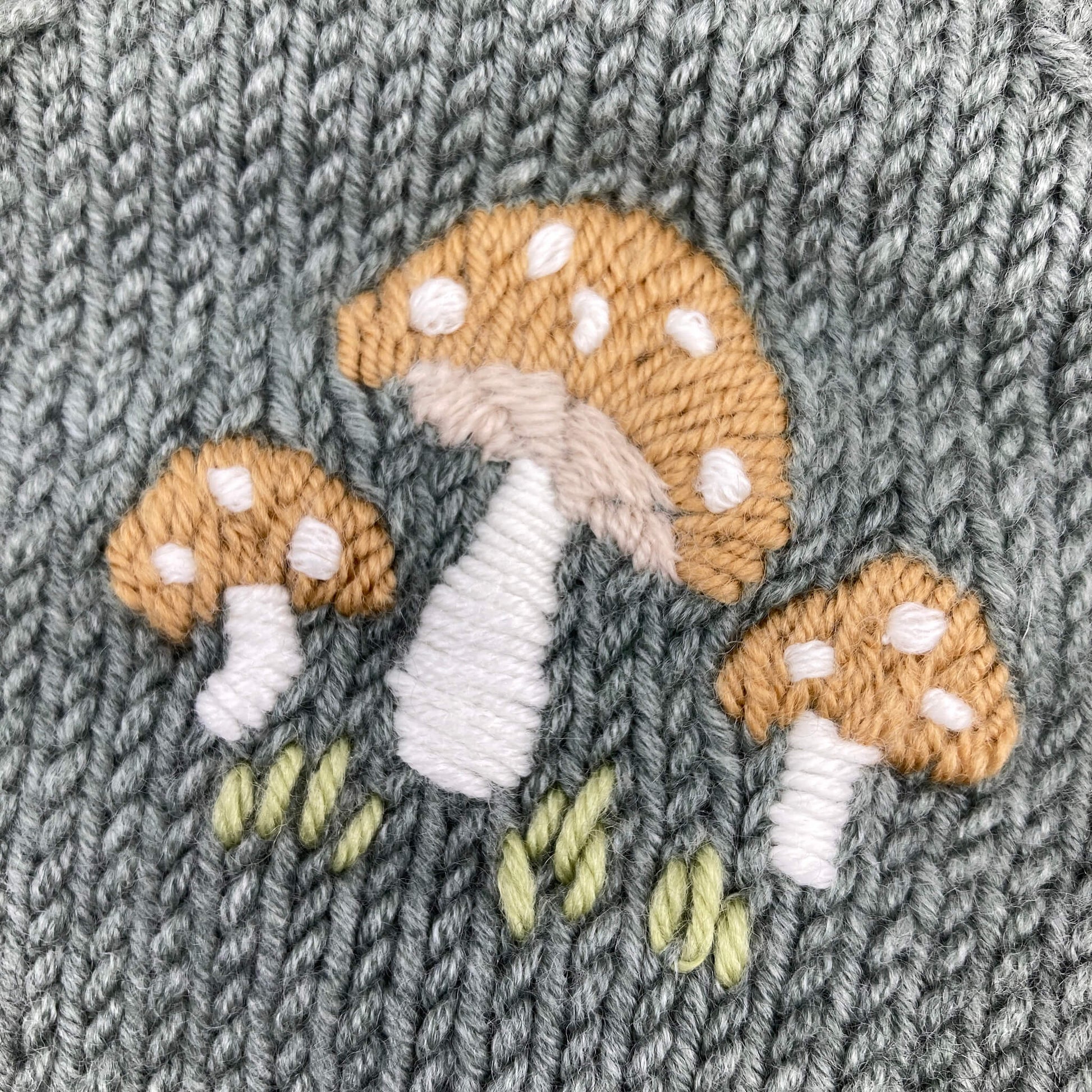 close up photo of mushroom embroidery on romper knitting pattern