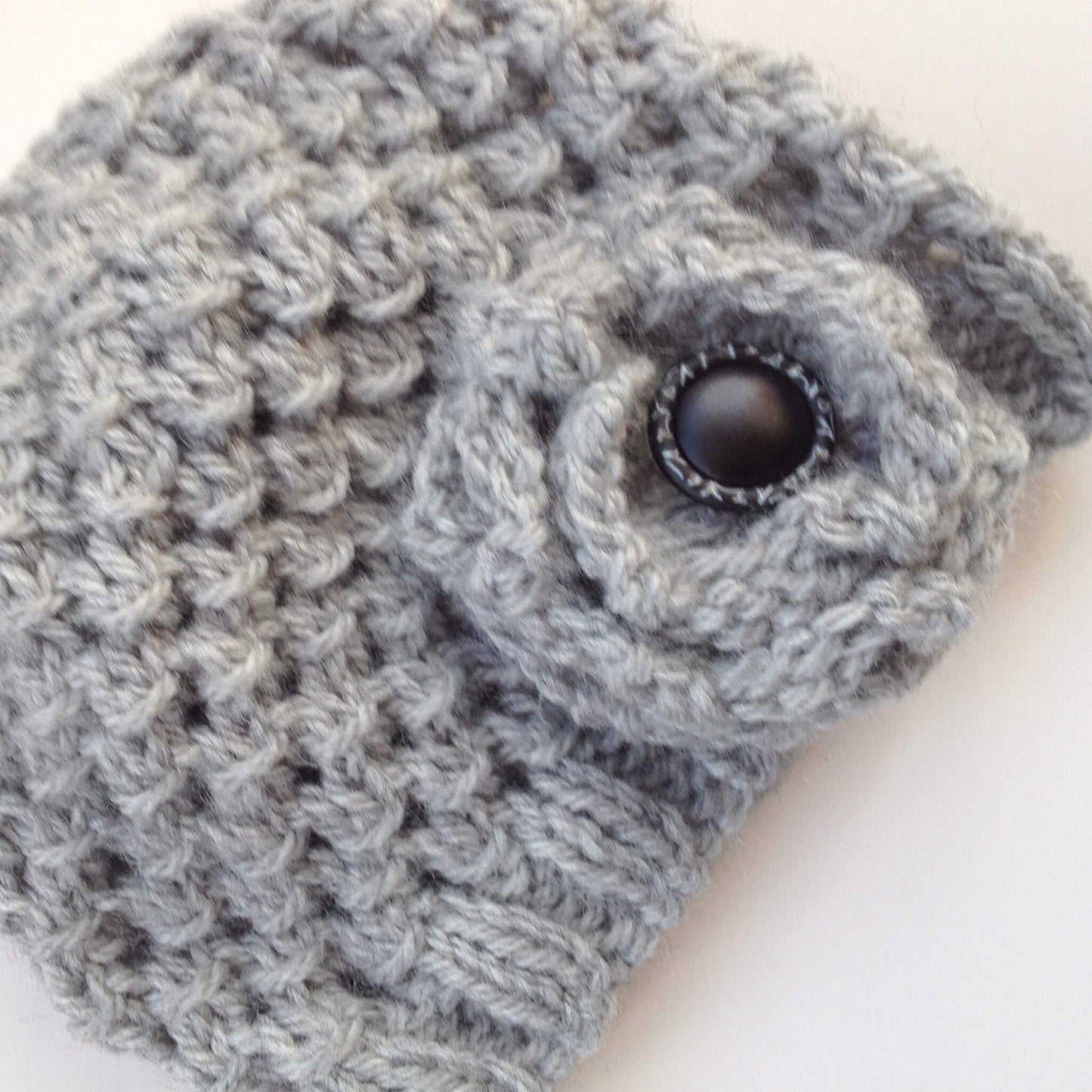 a quick knit hat pattern with a flower embellishment, both knitted in grey yarn