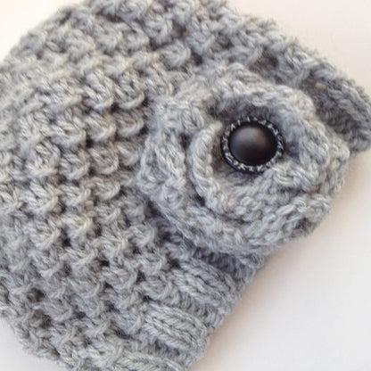 a quick knit hat pattern with a flower embellishment, both knitted in grey yarn