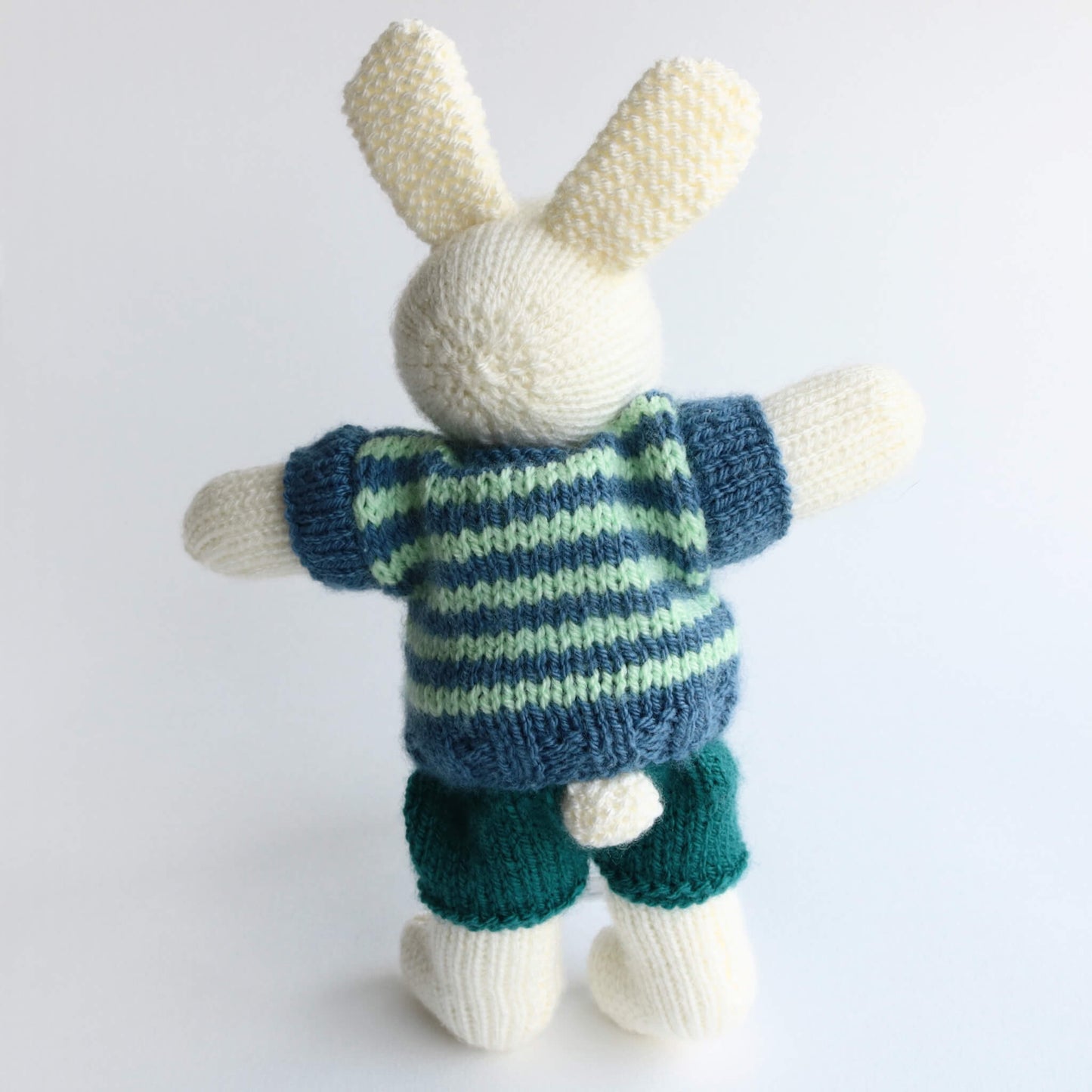 rabbit doll knitting pattern. the rabbit in the photo has his back towards the camera so you can see that he has a tail