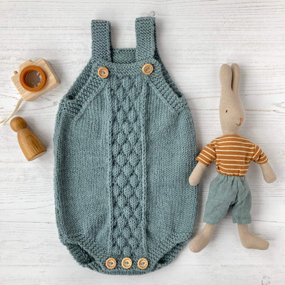 romper knitting pattern with bubble stitch design flatlay with toys to either side