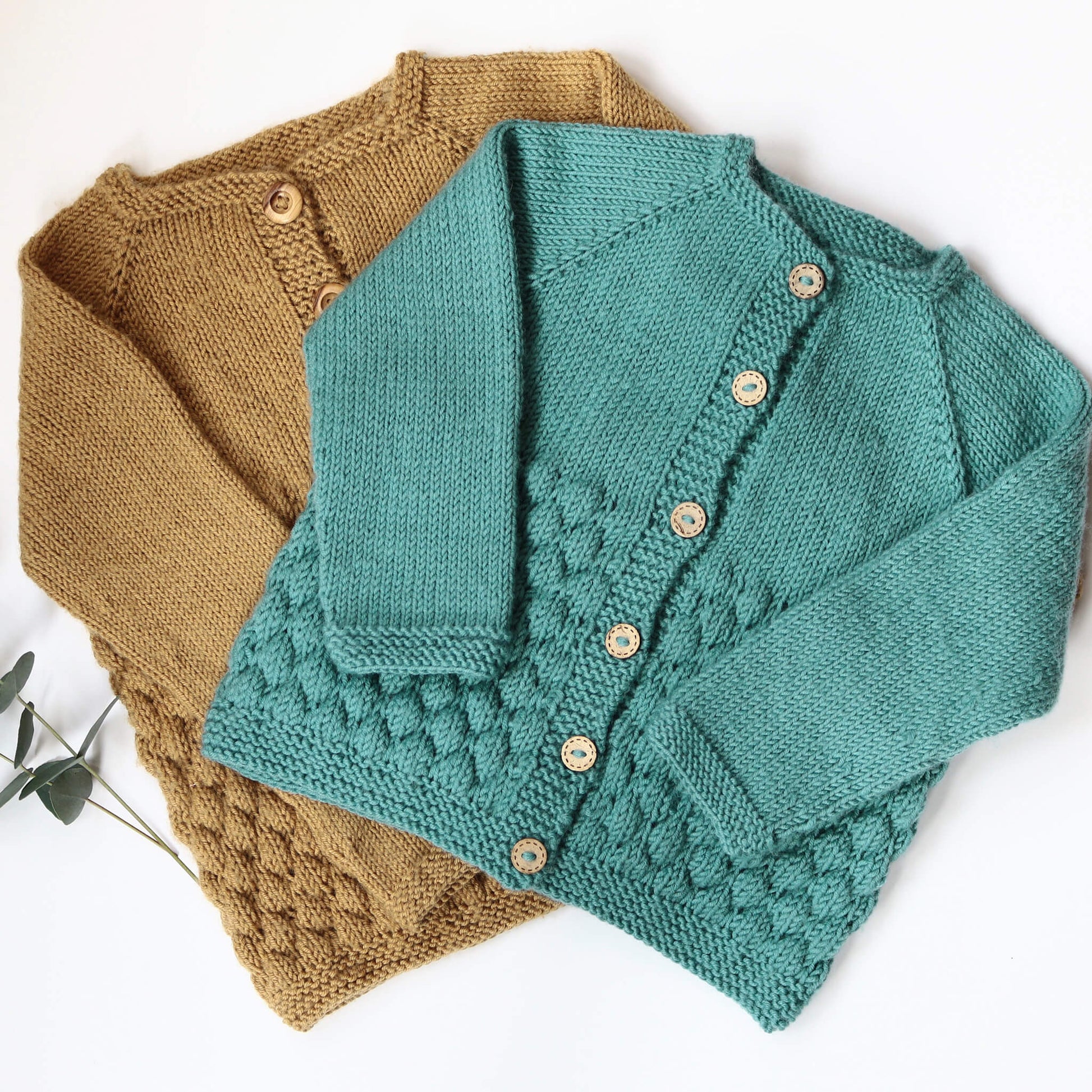 two cardigans in mustard and turquoise knit as samples for a top down knitting pattern for a baby cardigan