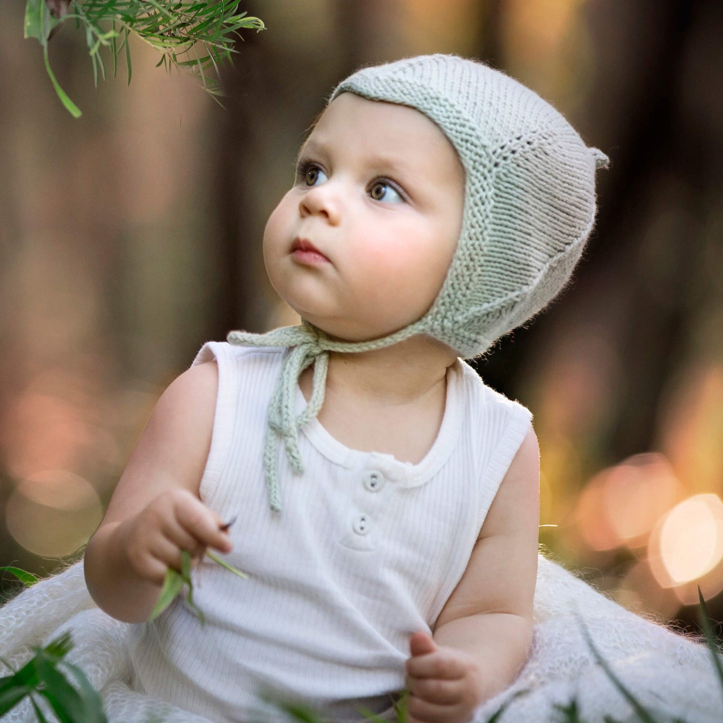 vintage pixie hat knitting pattern shown in pale green modelled by a toddler 